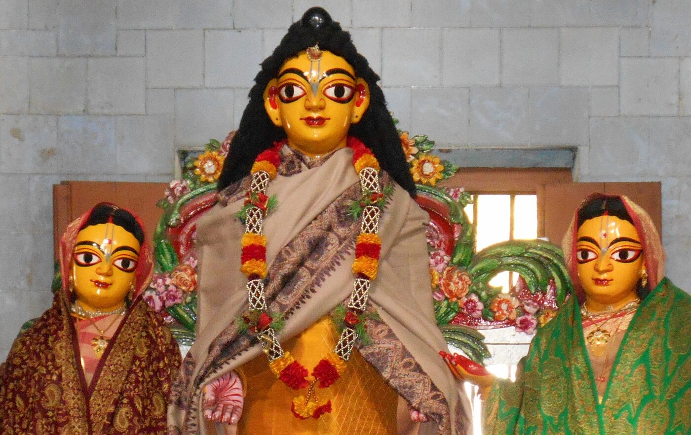 Sri Nityananda Prabhu flanked by Vasudha Devi and Jahnava Devi, among the wooden deities preserved at Sribas Angan, Nabadwip.
