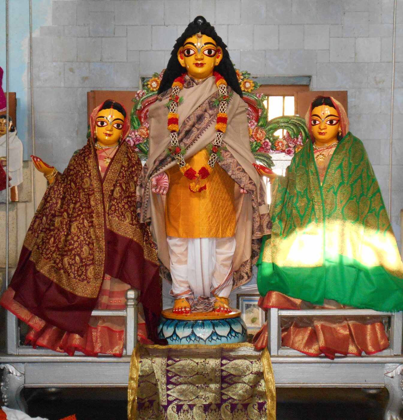 Wooden deities of Sri Nityananda Prabhu with his two consorts, Vasudha Devi and Jahnava Devi, at Sribas Angan in Nabadwip.