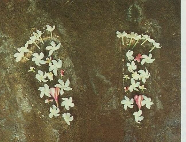 Shyamananda Prabhu’s footprints imprinted in stone, decorated with flowers