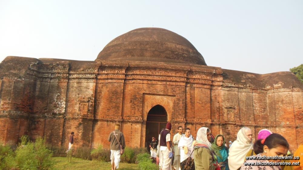 A photograph of the historic domed brick fort structure at Ramakeli (Ramkeli), Malda, Bengal, with pilgrims gathered in front of its entrance archway.