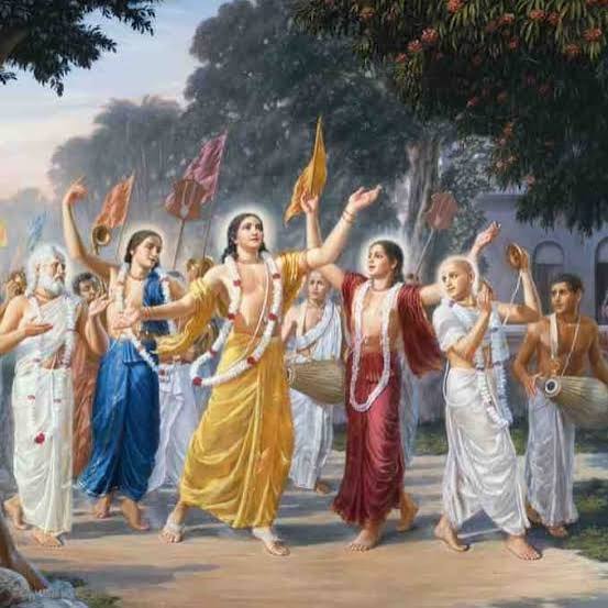 Devotional painting of a sankirtana procession with Sri Chaitanya Mahaprabhu dancing among associates carrying flags and mrdangas - reposted on ISKCON Desire Tree's Vakresvara Pandita appearance-day article by Ramai Swami.